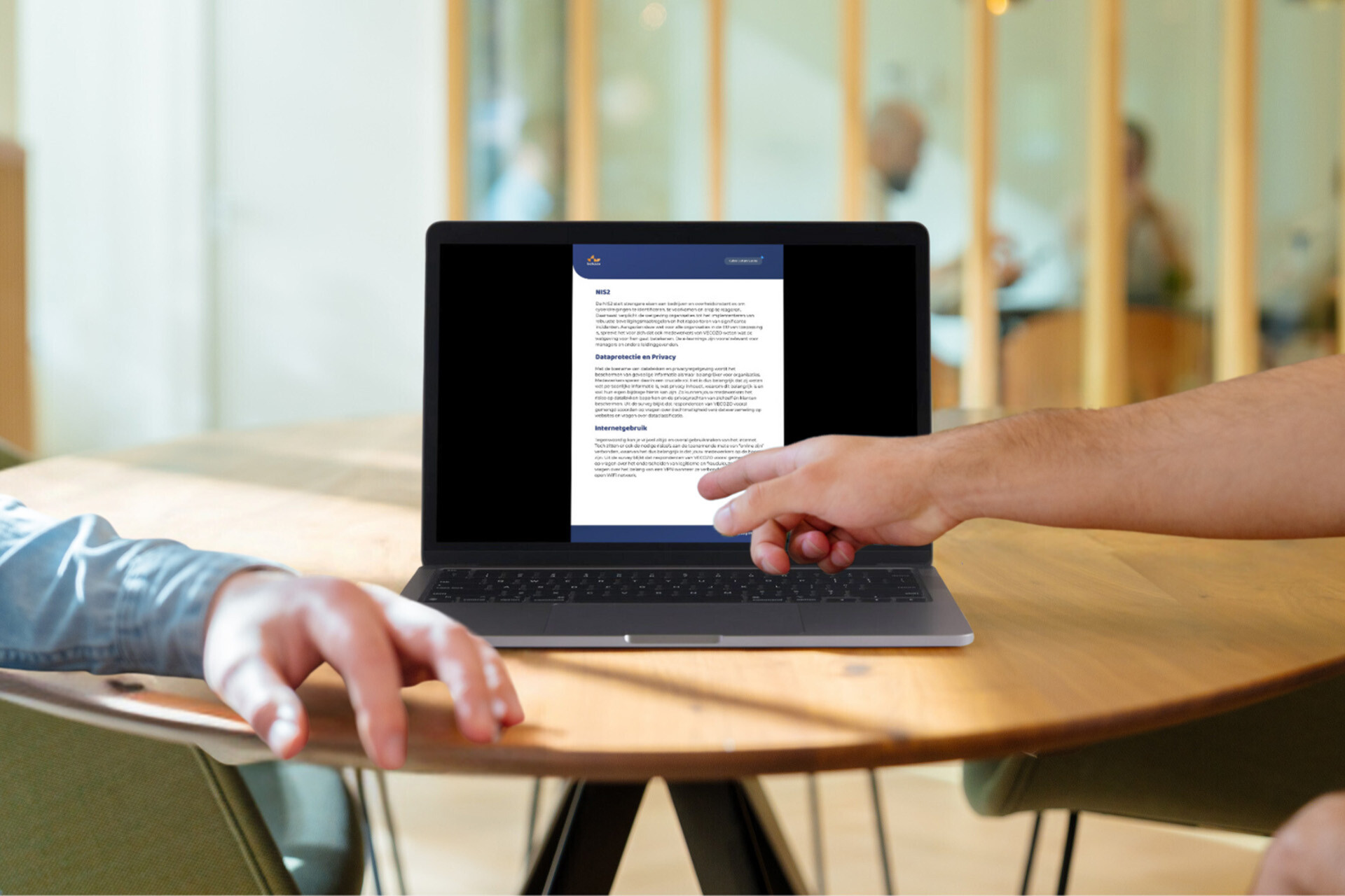 Een medewerker toont de bevindingen van de cyber surveys op een laptop, wat helpt bij het verbeteren van cybbersecuritystrategieën.