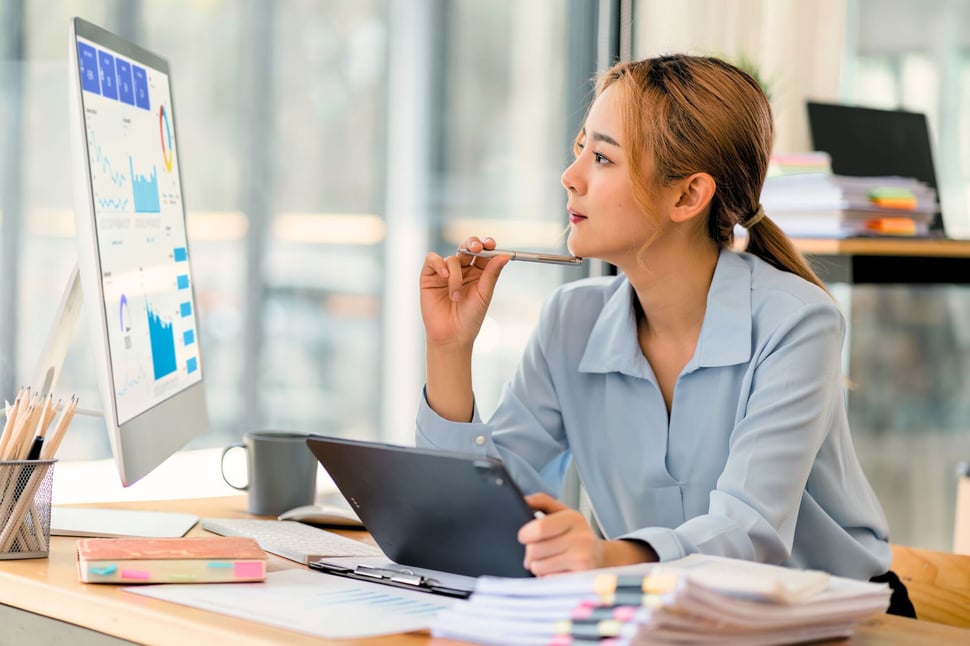 Een Security Awareness Officer analyseert KPI's op haar computer, waarbij ze nadenkt over de volgende stappen in het security awareness programma.