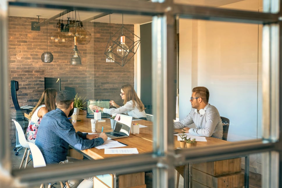 Een team van nieuwe medewerkers neemt deel aan een security awareness onboarding sessie in een moderne kantooromgeving.