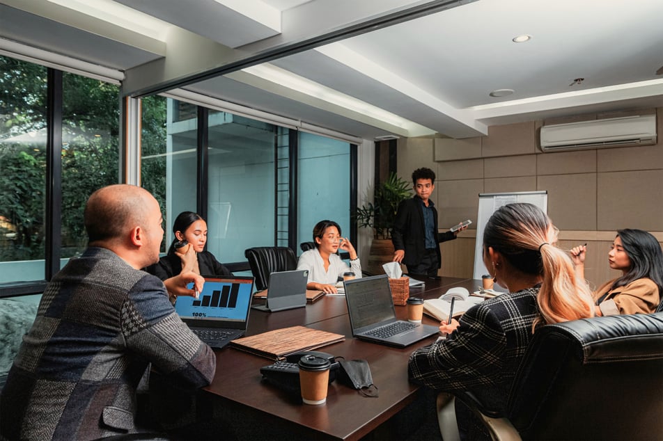 Een team in een vergaderruimte bespreekt de evaluatie van een cybersecurity incident response plan, met focus op verbeterpunten.