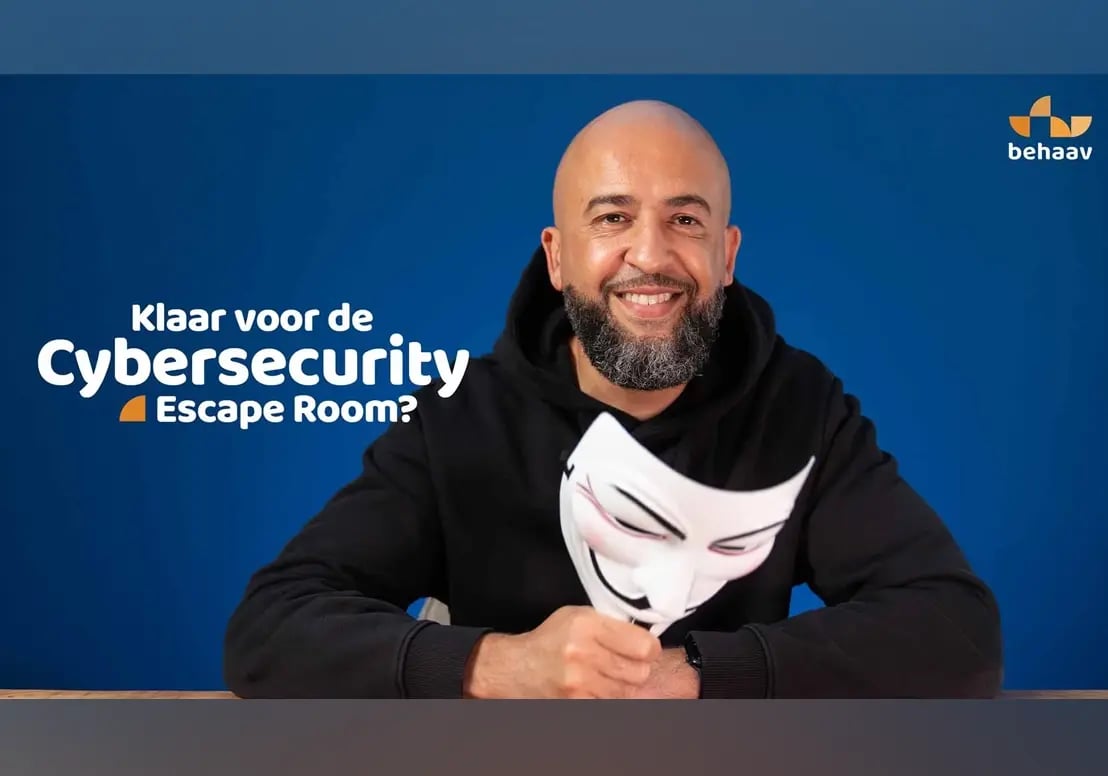 Thumbnail van een man die achter een bureau zit en een Anonymous-masker vasthoudt met de tekst: Klaar voor de Cybersecurity Escape Room?